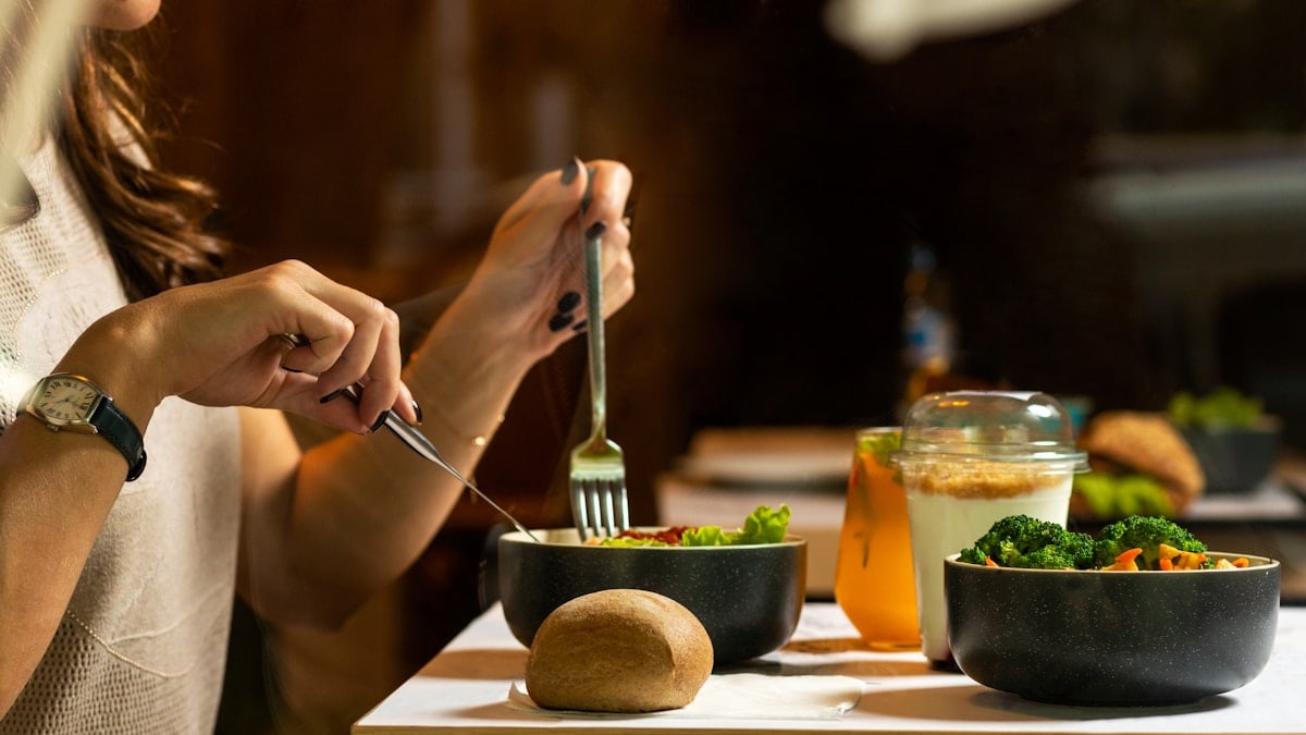 Women eating tasty chicken salad with dessert